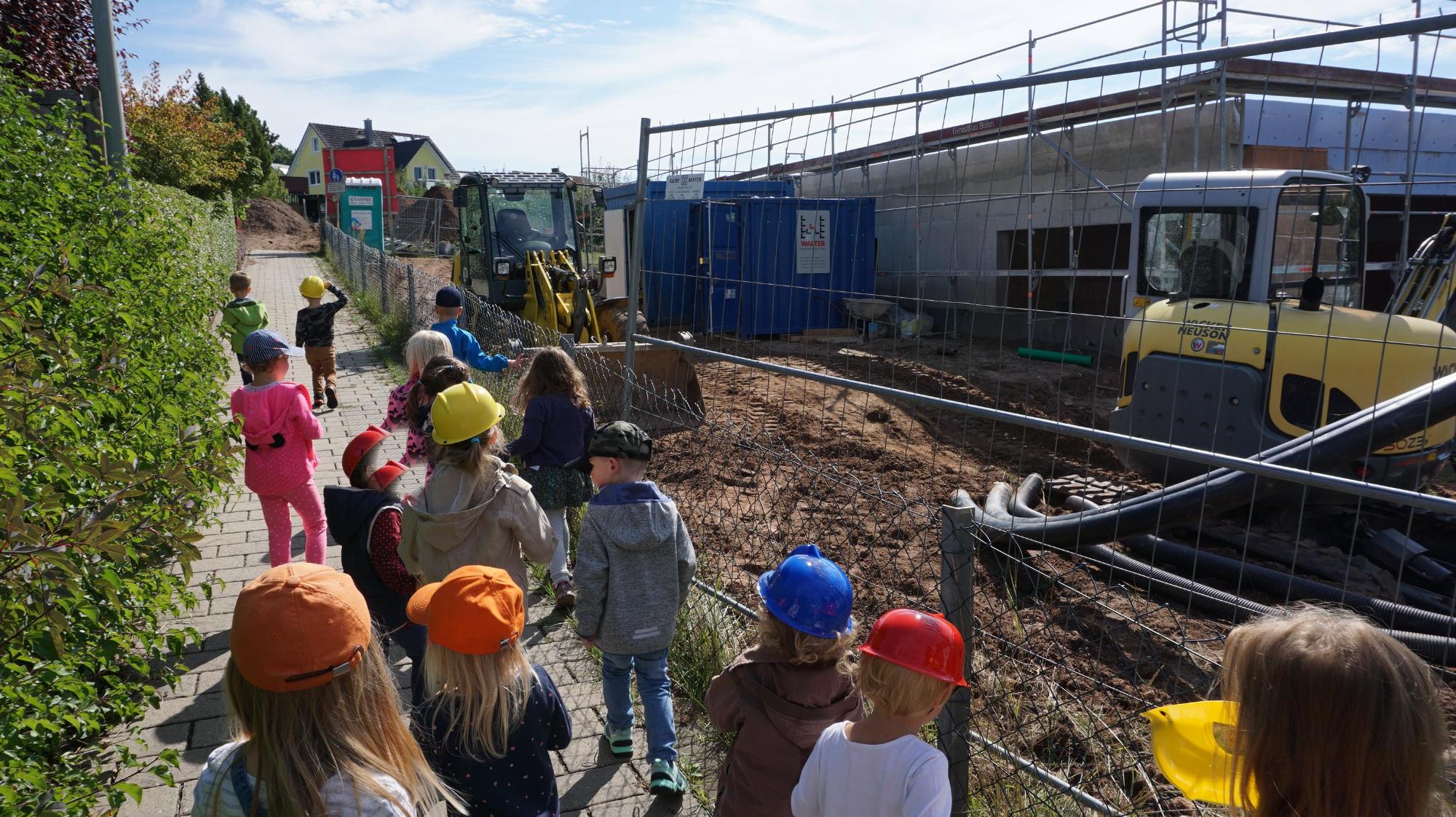 Kleine Bauarbeiter auf dem Weg zur  Baustelle um den Arbeitern zuzuschauen